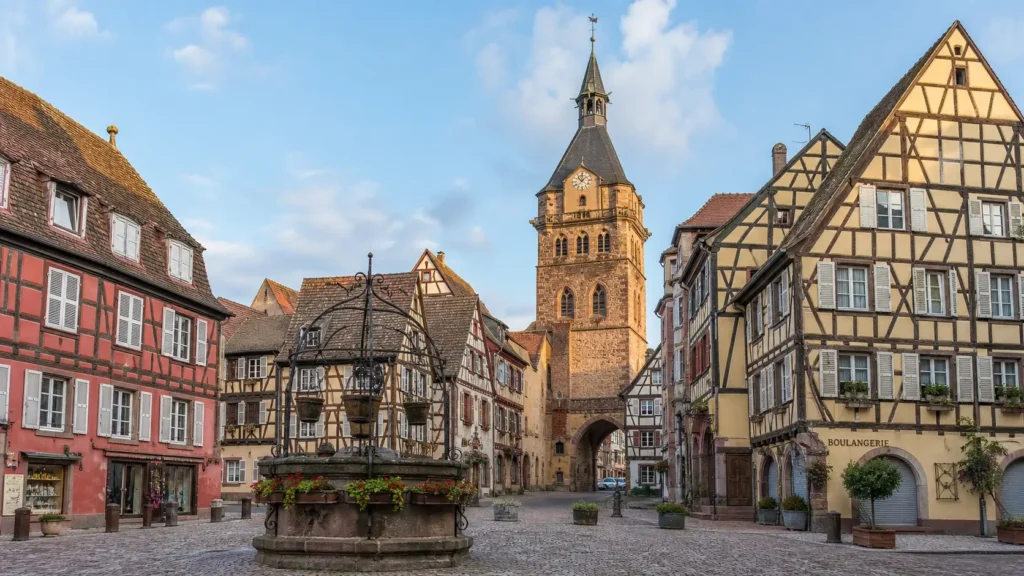 Obernai’s central square with half-timbered houses, the Six-Bucket Well and the Kapellturm belfry.